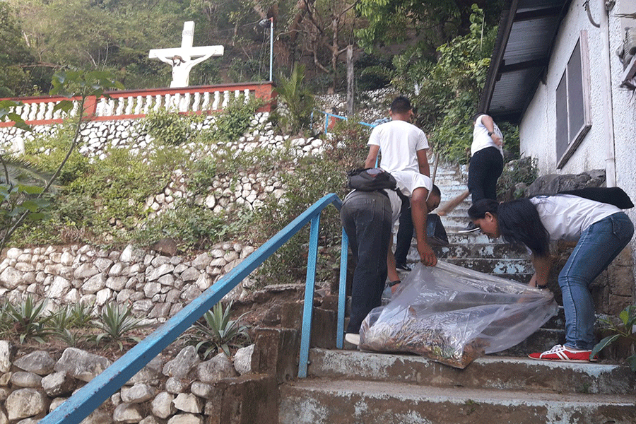 Security personnel carry bags of garbage and paint the staircase for the patrons of Grotto of Our Lord of Pardon in time for Holy Week.