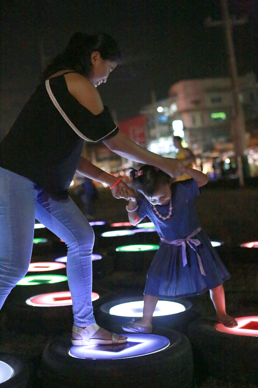 Mother and child play at the public solar light art installation in SM City Marilao. The installation conveys the message of sustainability in an engaging way through delightful light and designs featuring recycled tires and solar powered light- emitting diode or LED lights.