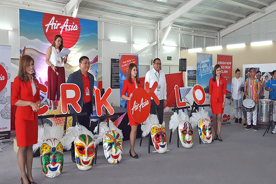CIAC’s Cauguiran is all smiles in joining the flight attendants of Air Asia and its CEO Dexter Comendador and with growing number of CRK flights. --Photo by Noel G. Tulabut